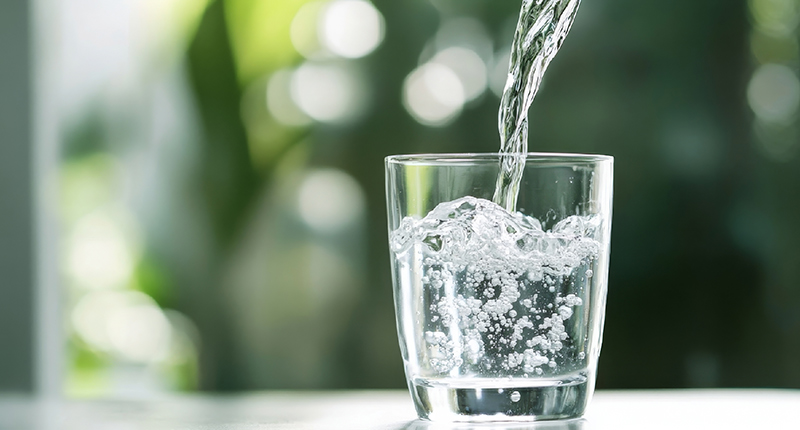 Water being poured into a clear glass.