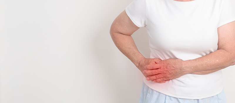 Elderly woman experiencing discomfort or pain in her waist area.