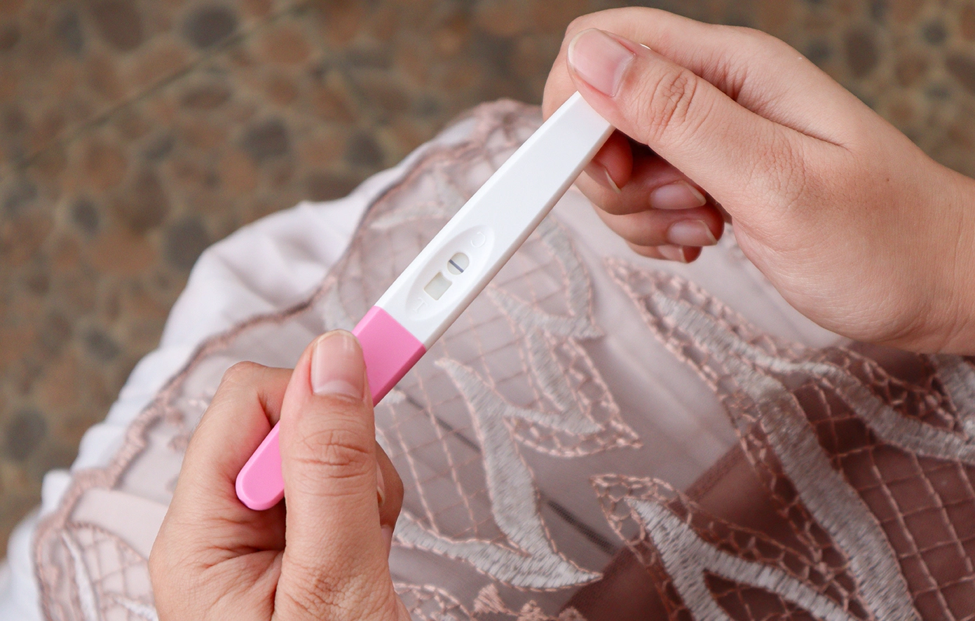Close-up of a woman holding a negative pregnancy test result