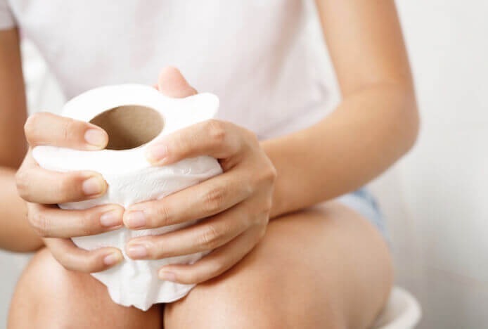 Woman holding a tissue, suffering from a urinary tract infection (UTI)