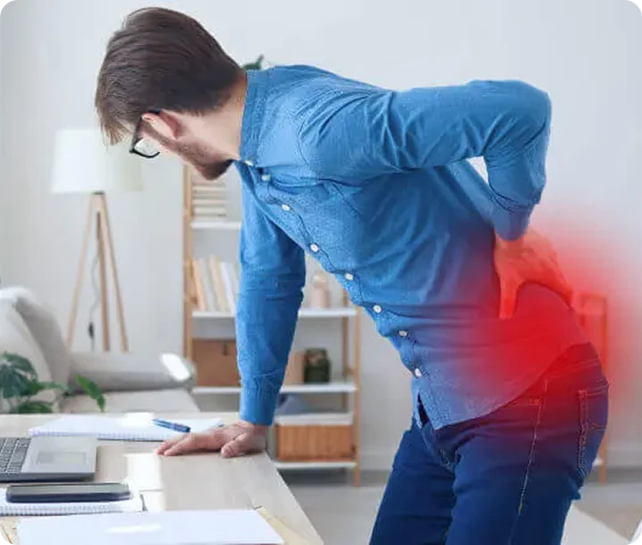 A young man with back pain holds his lower body