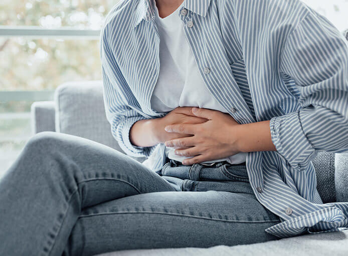 Woman in pain holding belly stomach