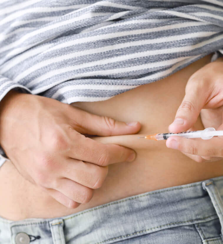 A woman injects follicle-stimulating hormone (FSH) into her abdomen